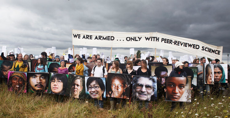 Boucliers pour se protéger de la violence policière, avec des portraits de personnes victimes de catastrophes climatiques.